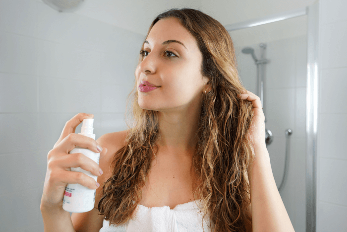 melhores produtos para finalizar cabelos ondulados - mulher aplicando spray capilar