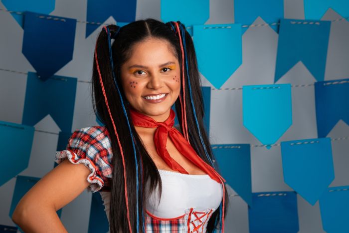 mulher com trajes de festa junina e penteado com fitas